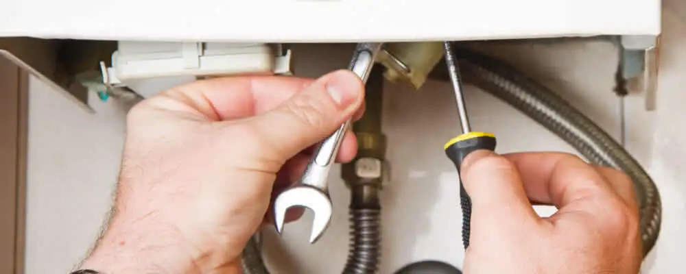 Boiler repair technician tightening pipe fittings and connections in Saint Petersburg, FL