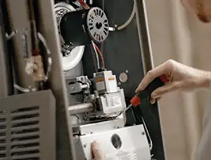 Furnace repair technician inspecting internal components and wiring in Saint Petersburg, FL