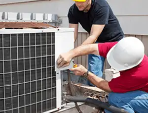 HVAC technicians repairing an outdoor AC unit on a rooftop in Saint Petersburg, FL