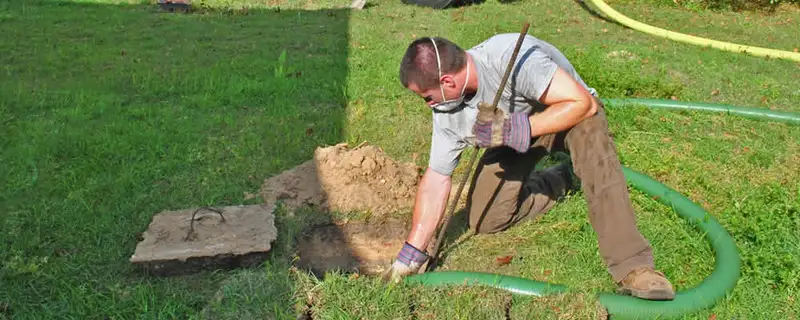 Septic pumping technician servicing a residential septic tank in Saint Petersburg, FL
