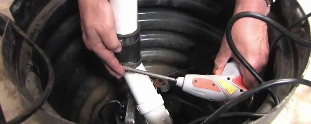 Sump pump installation technician connecting PVC discharge piping in Saint Petersburg, FL