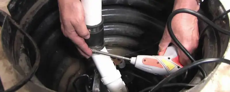 Sump pump installation technician connecting PVC discharge piping in Saint Petersburg, FL