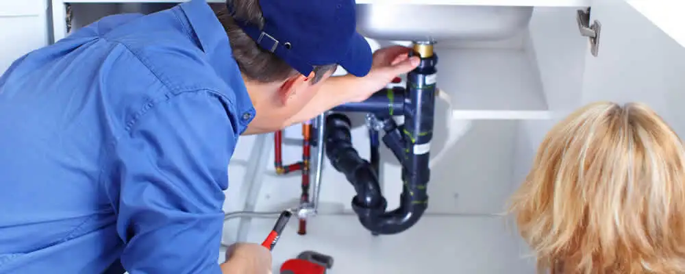 Plumber repairing under-sink drain pipes and fittings in Saint Petersburg, FL